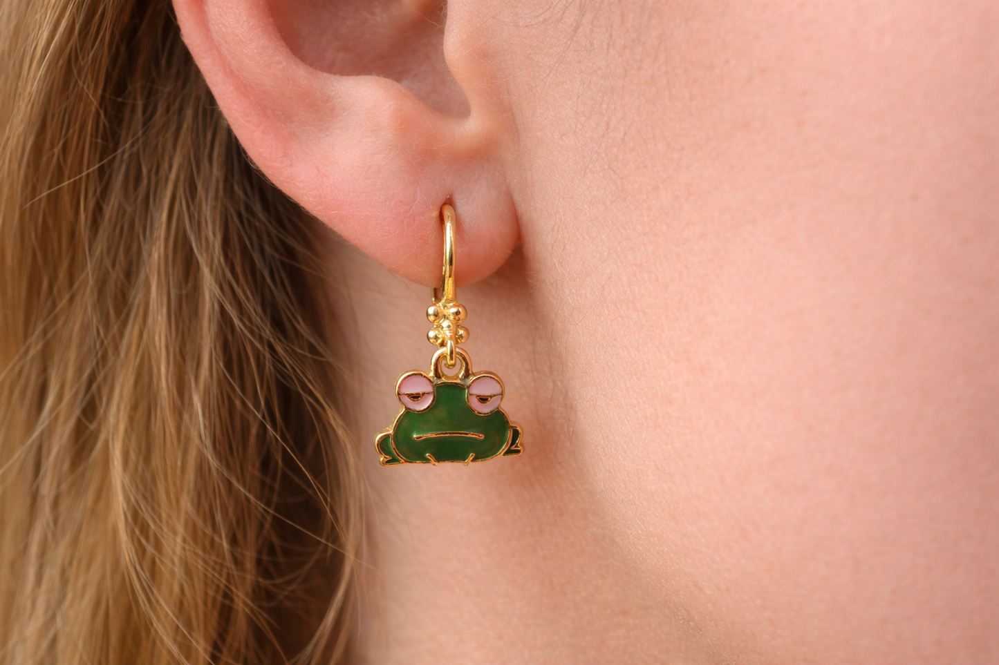 Goudkleurige oorbellen met groene kikker
