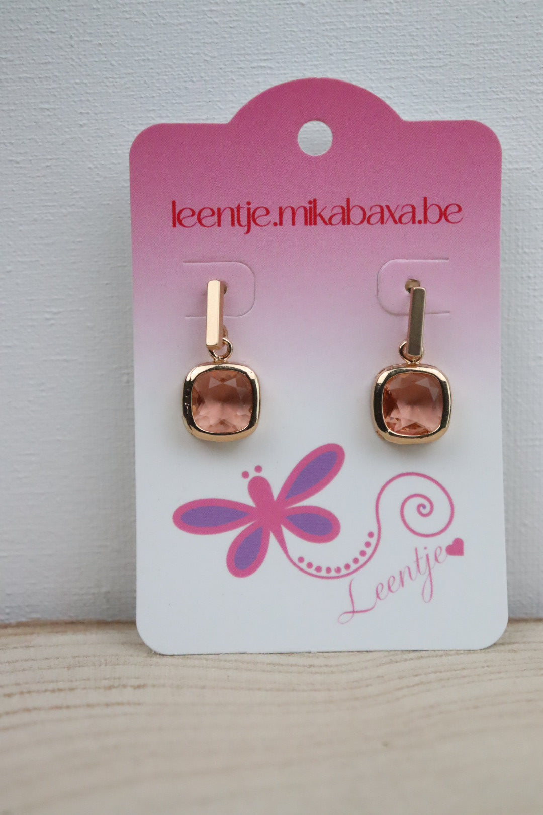 Goudkleurige staafjes met vierkante perzikkleurige hanger