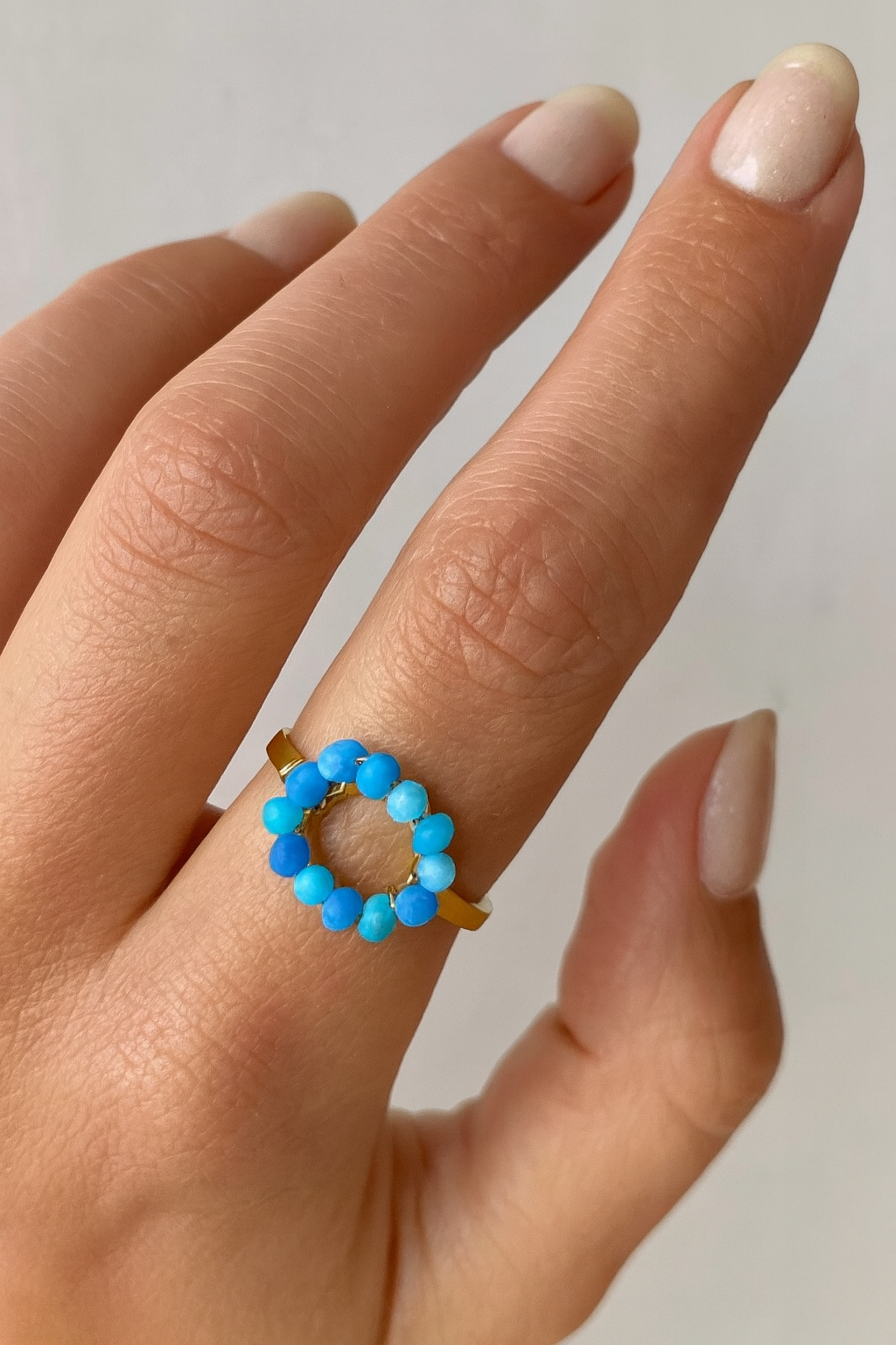 Stainless steel goudkleurige ring met blauwe glaskralen