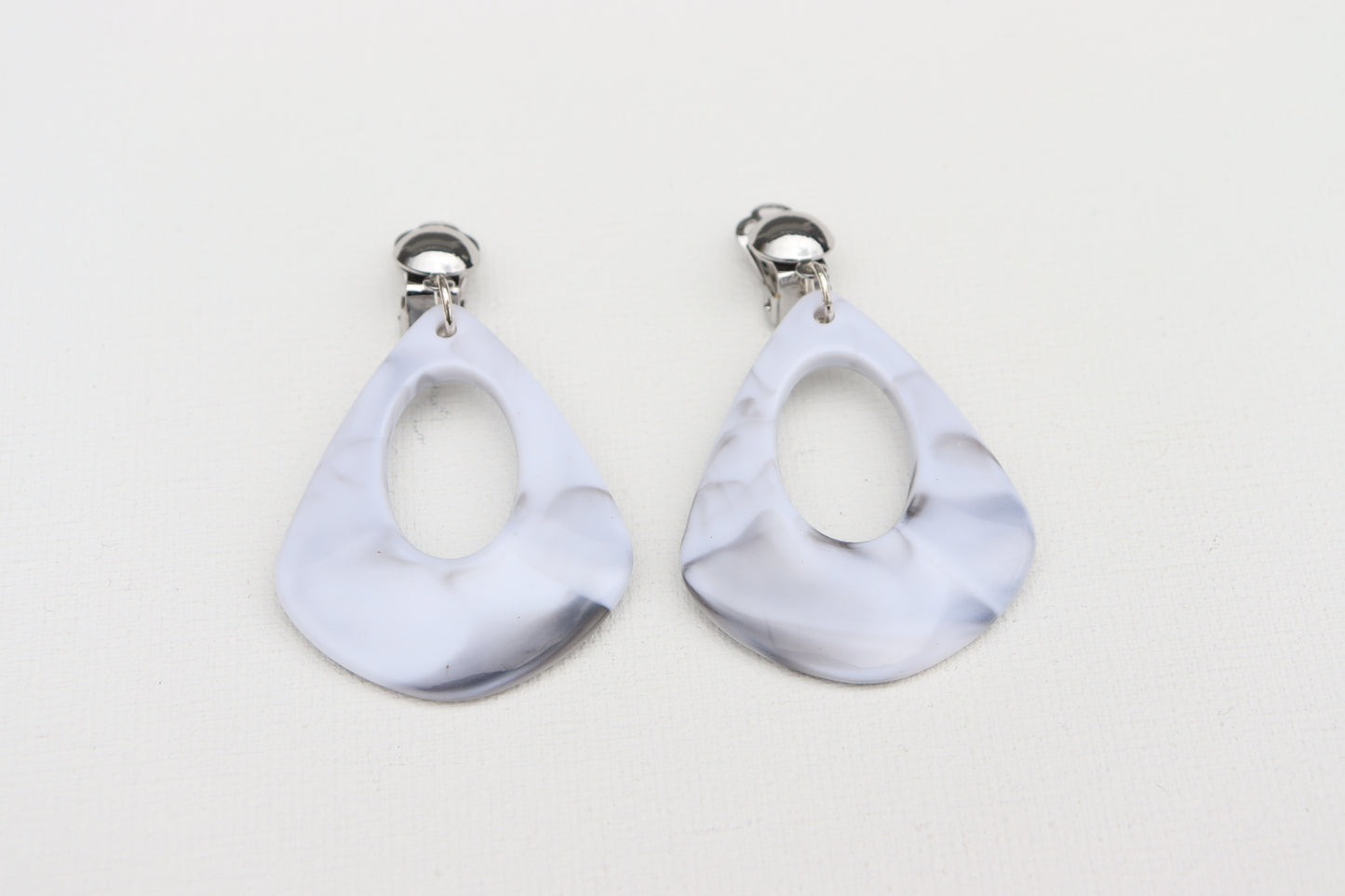 Zilverkleurige clip oorbellen met gemarmerd grijze afgeronde driehoek hanger