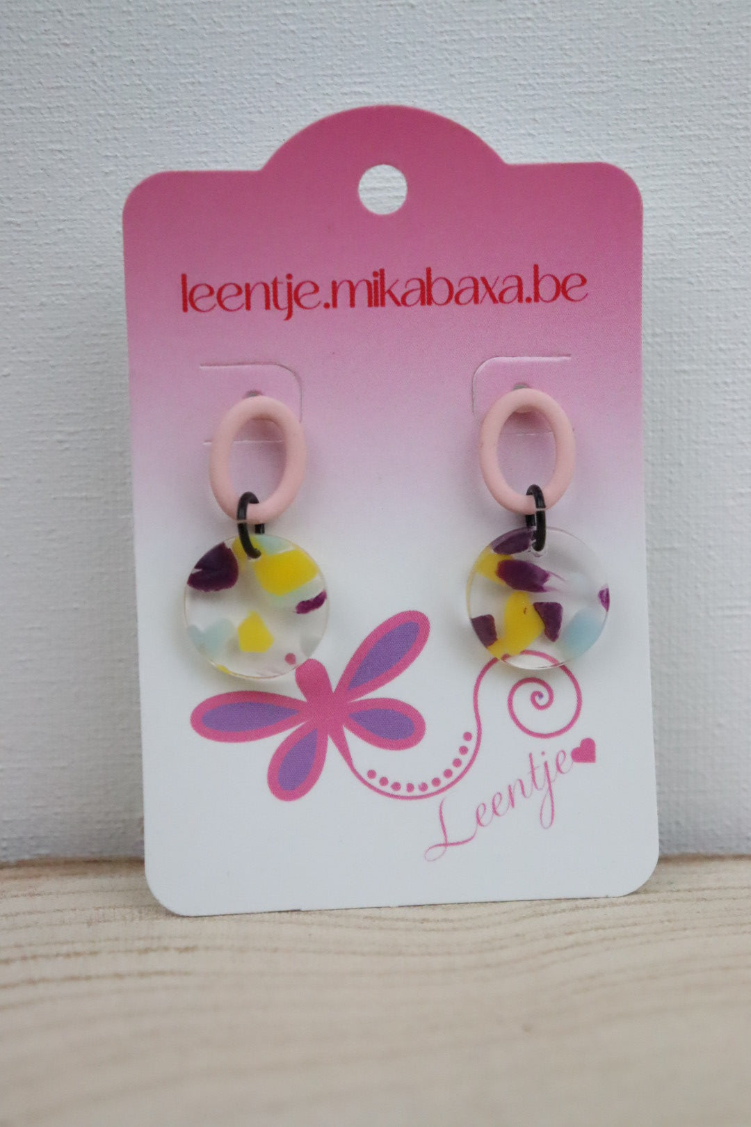 berubberde pastel roze ovale oorstekertjes met veelkleurige hanger