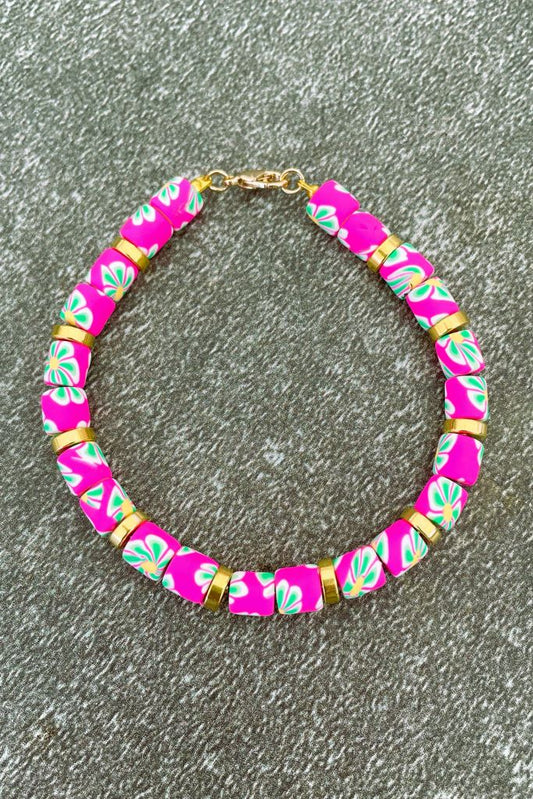 Armband met roze bloemetjes kralen en goudkleurige rondjes