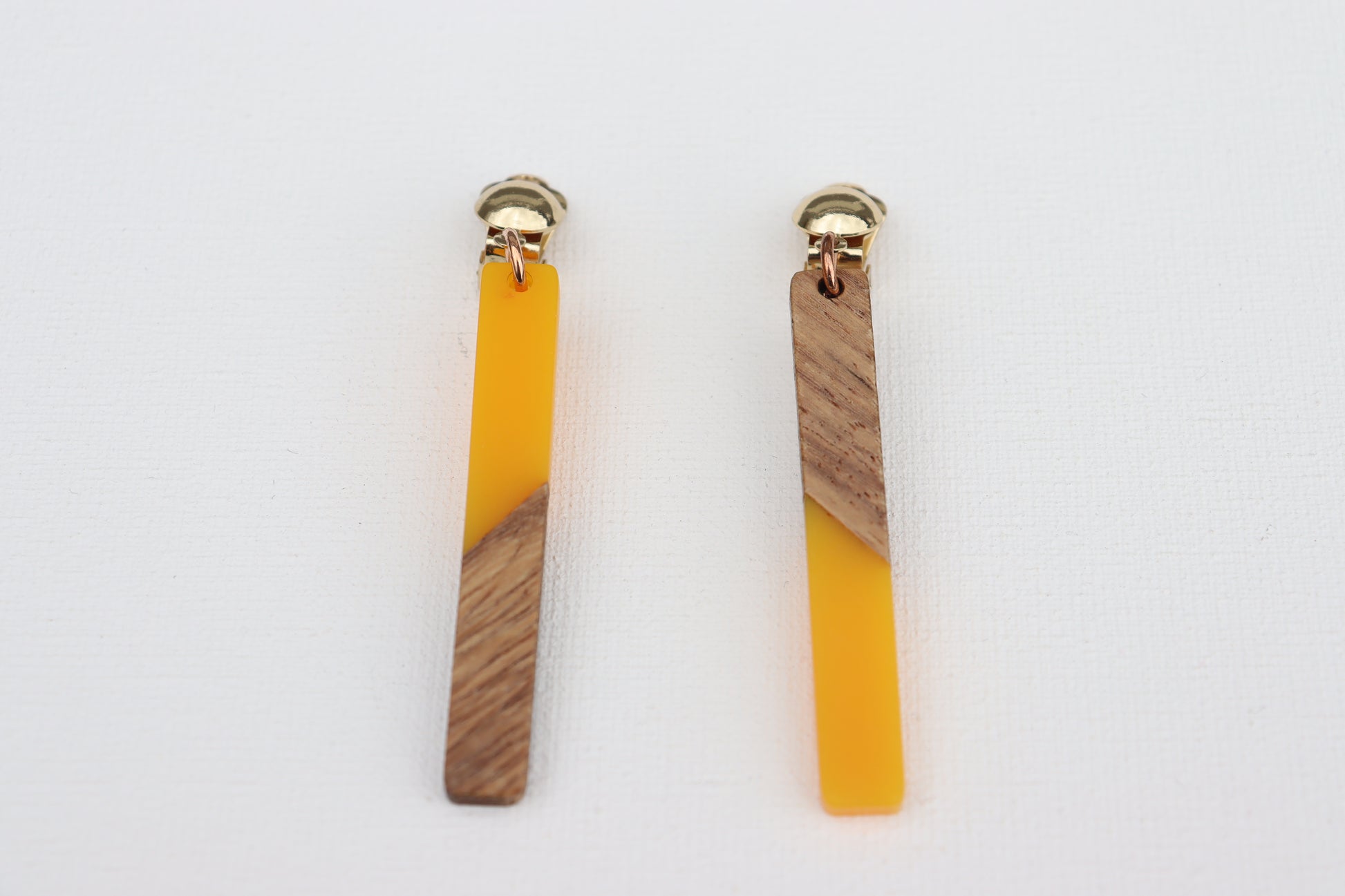 Goudkleurige clipoorbellen met houten gele hanger