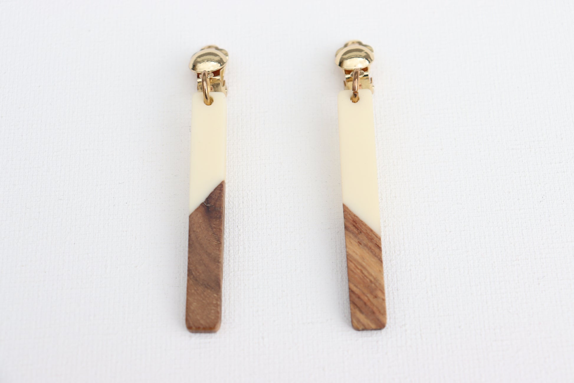 Goudkleurige clipoorbellen met houten witte hanger