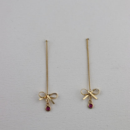 Goudkleurige ketting oorbellen met goudkleurige strik en ronde fuchsia hanger