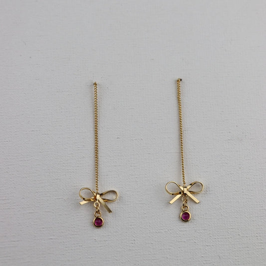 Goudkleurige ketting oorbellen met goudkleurige strik en ronde fuchsia hanger