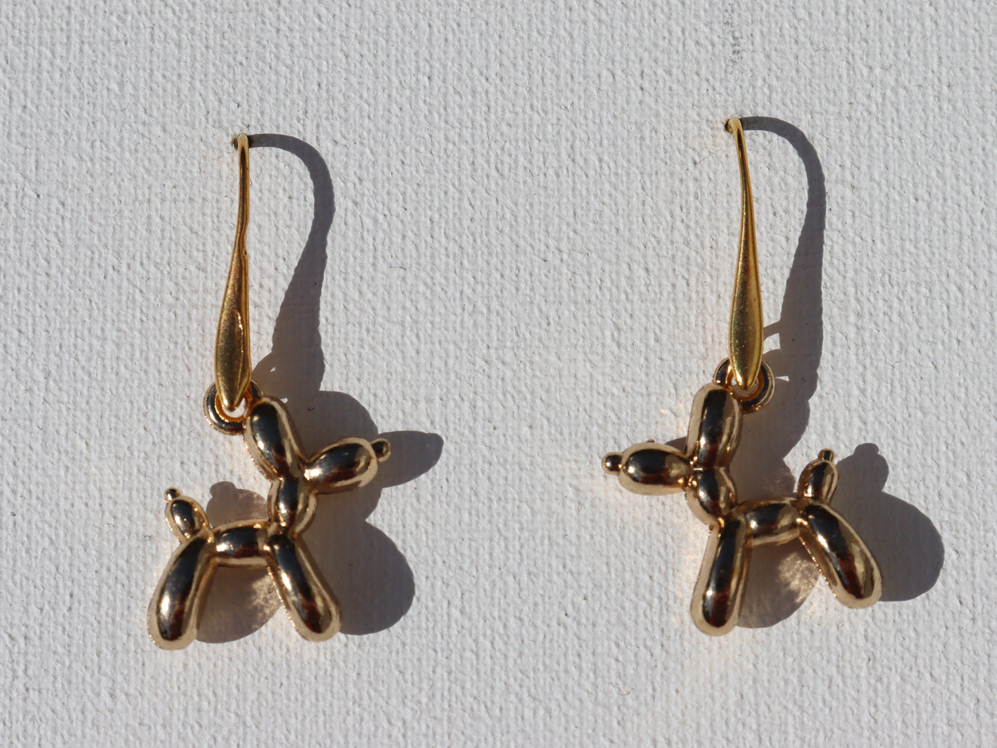 Goudkleurige oorhaken met goudkleurige ballon hond