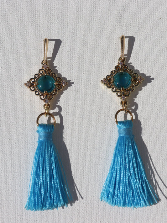 Goudkleurige oorhaken met goudkleurige blauwe steenhanger en blauwe floche