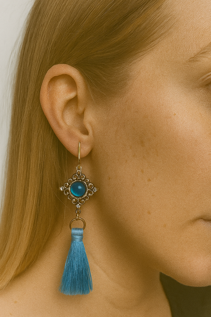 Goudkleurige oorhaken met goudkleurige blauwe steenhanger en blauwe floche