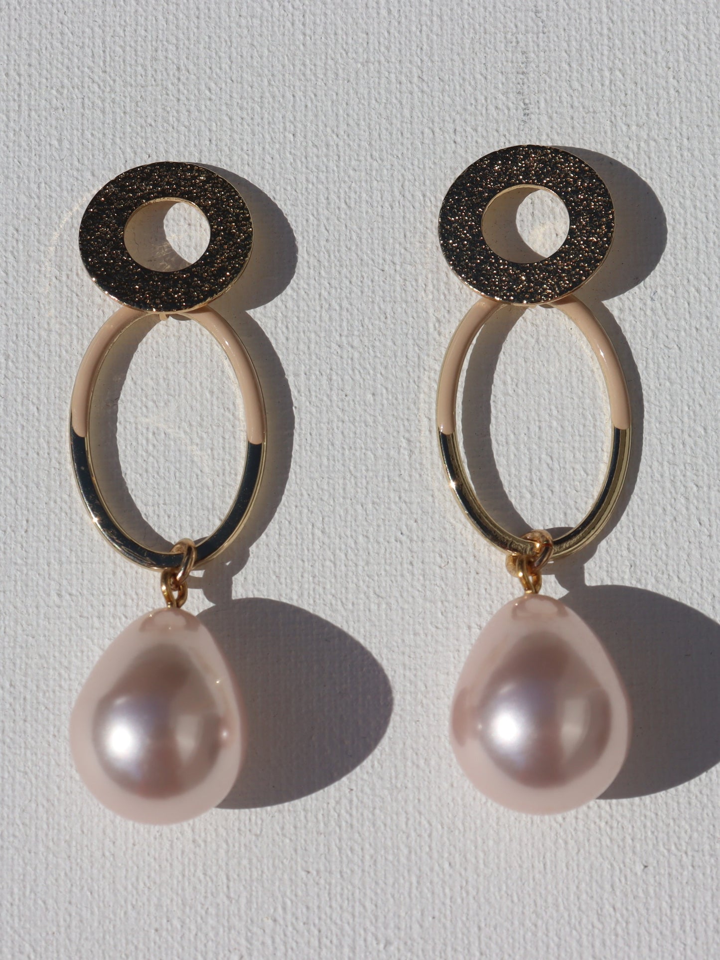 Goudkleurige open ring oorstekers met goudkleurige ovale hanger en roze parel