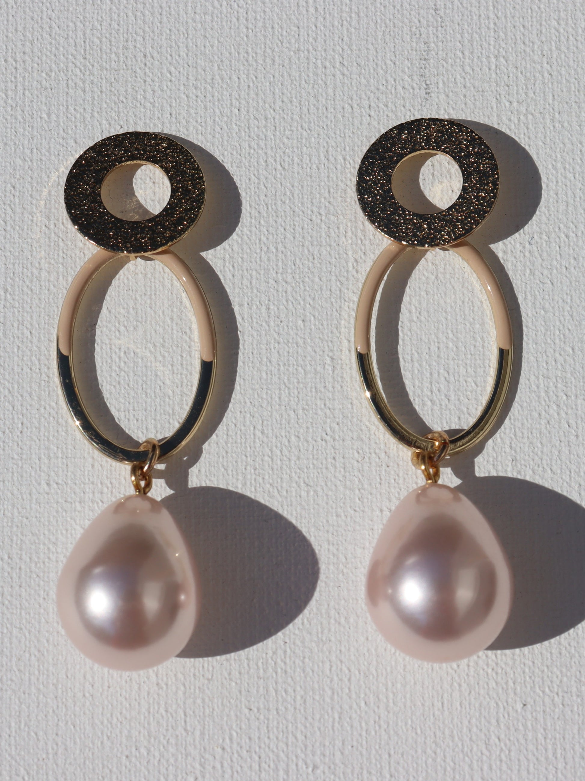 Goudkleurige open ring oorstekers met goudkleurige ovale hanger en roze parel