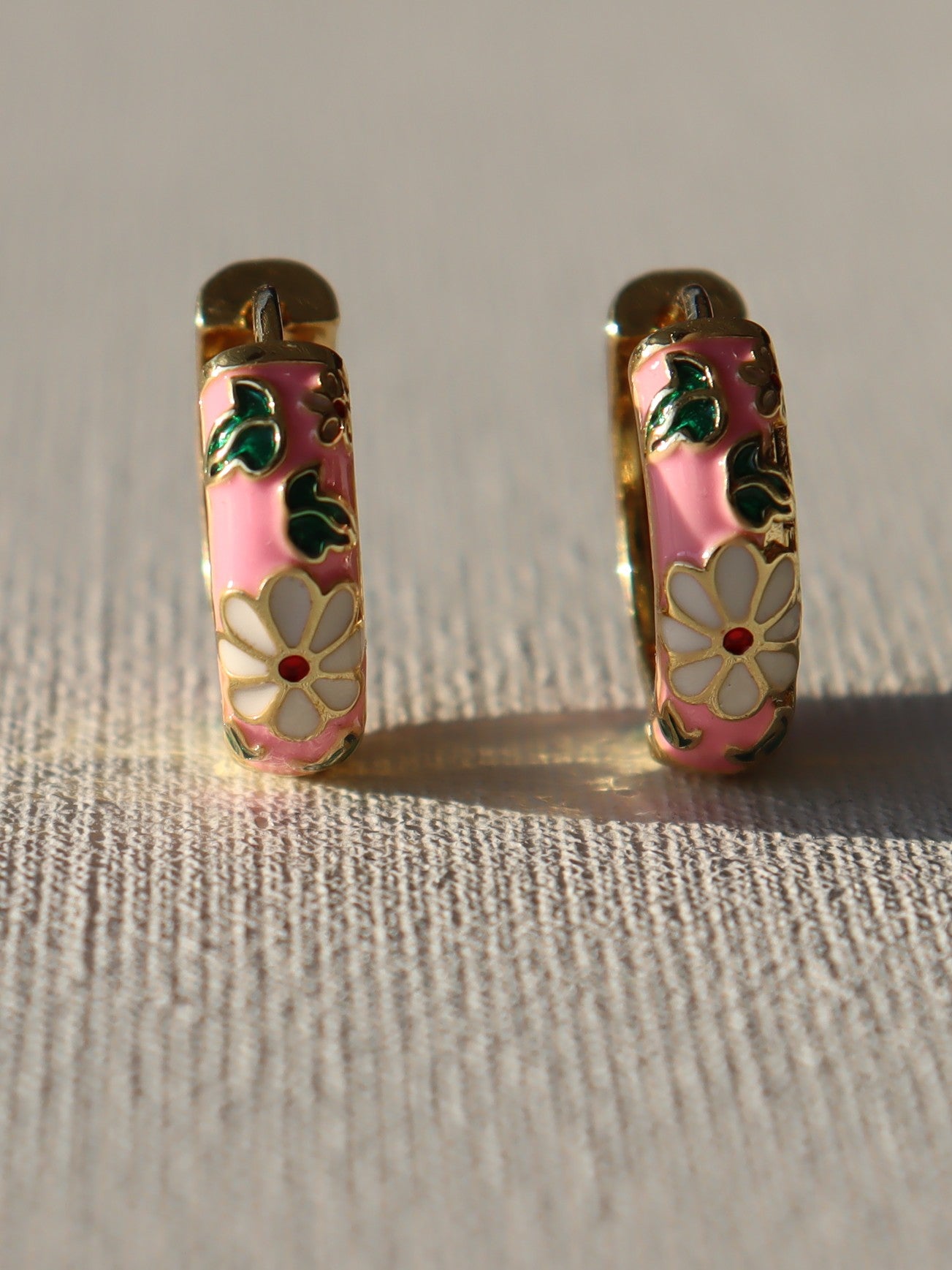 Goudkleurige creolen met witte bloemen en roze