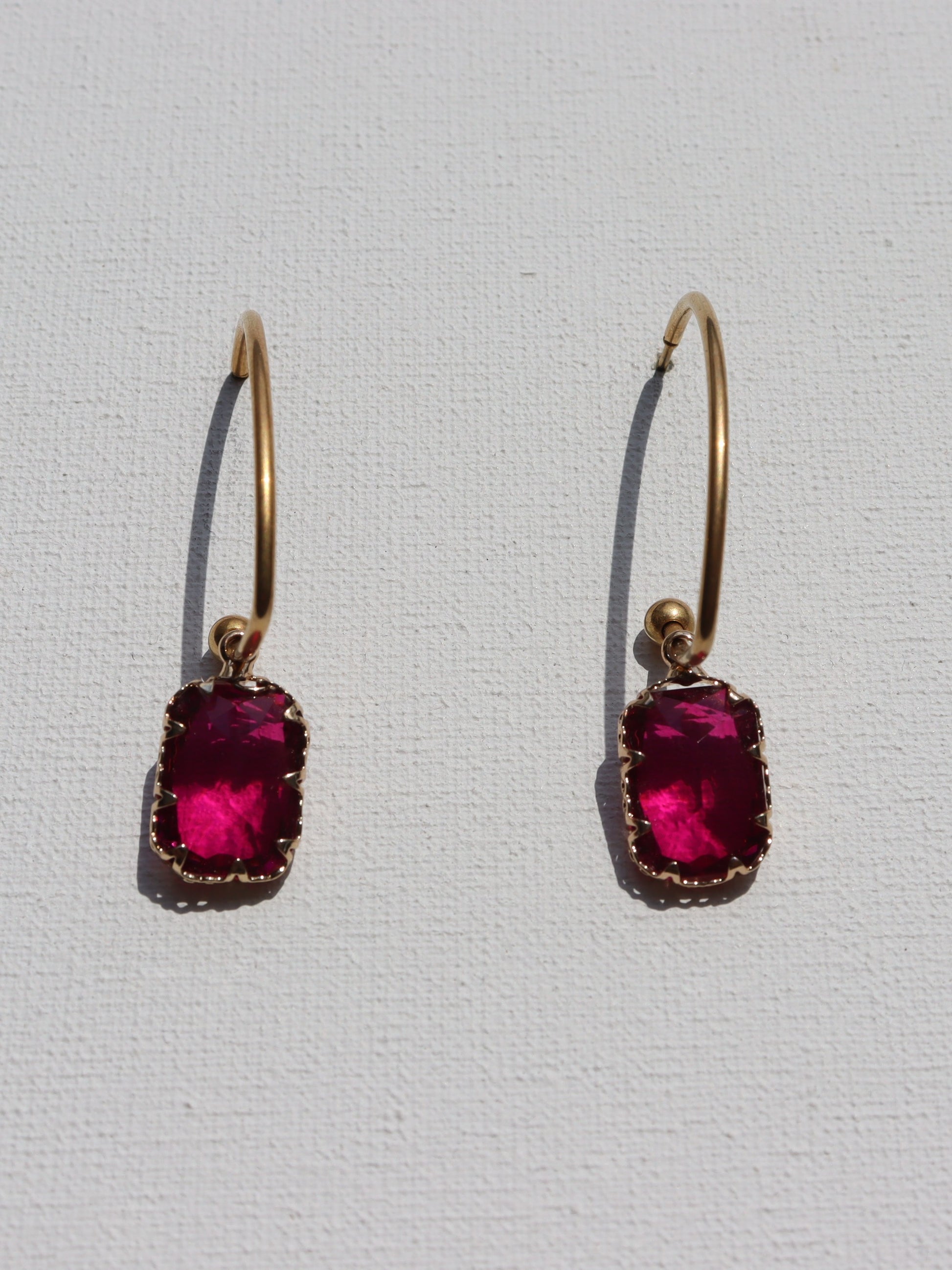 Goudkleurige oorbellen met fuchsia roze glas bedels
