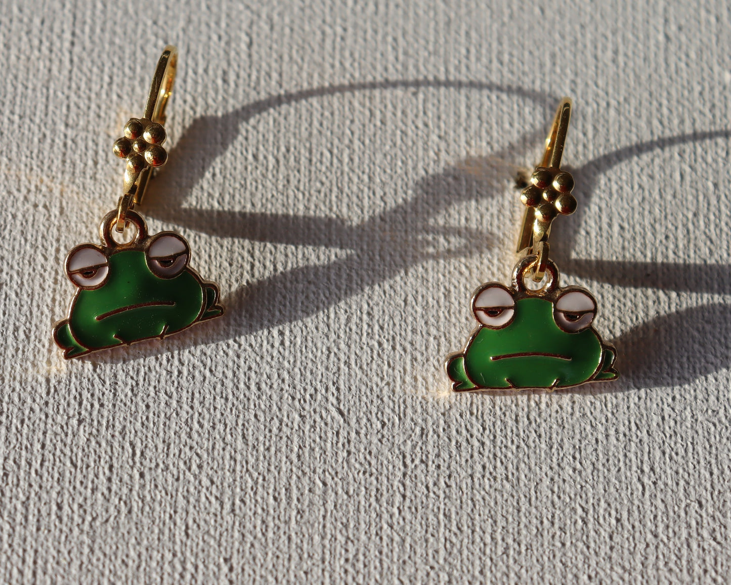 Goudkleurige oorbellen met groene kikker