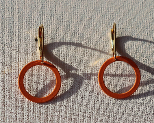 Goudkleurige oorbellen met oranje berubberde cirkel 