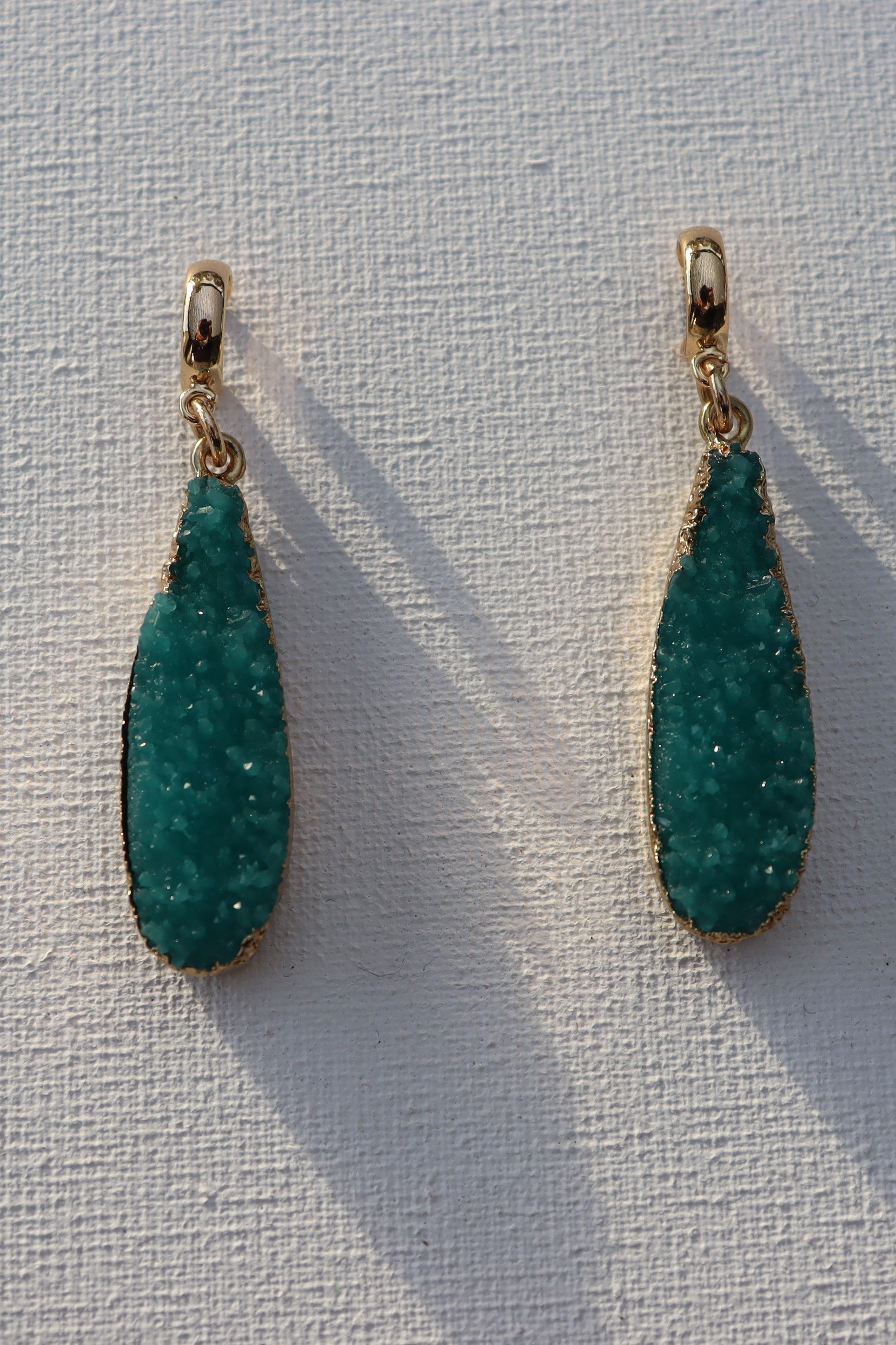 Goudkleurige oorbel ringen met blauwe geode hars hanger