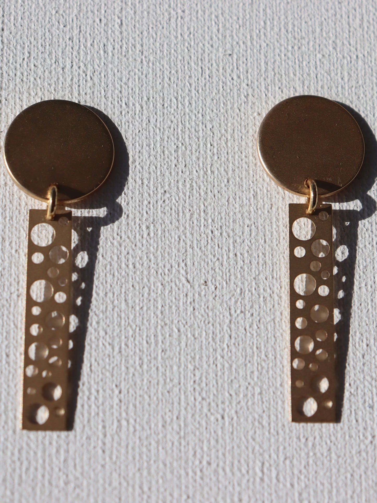 Goudkleurige ronde stekertjes met goudkleurige staafjes met ronde gaten