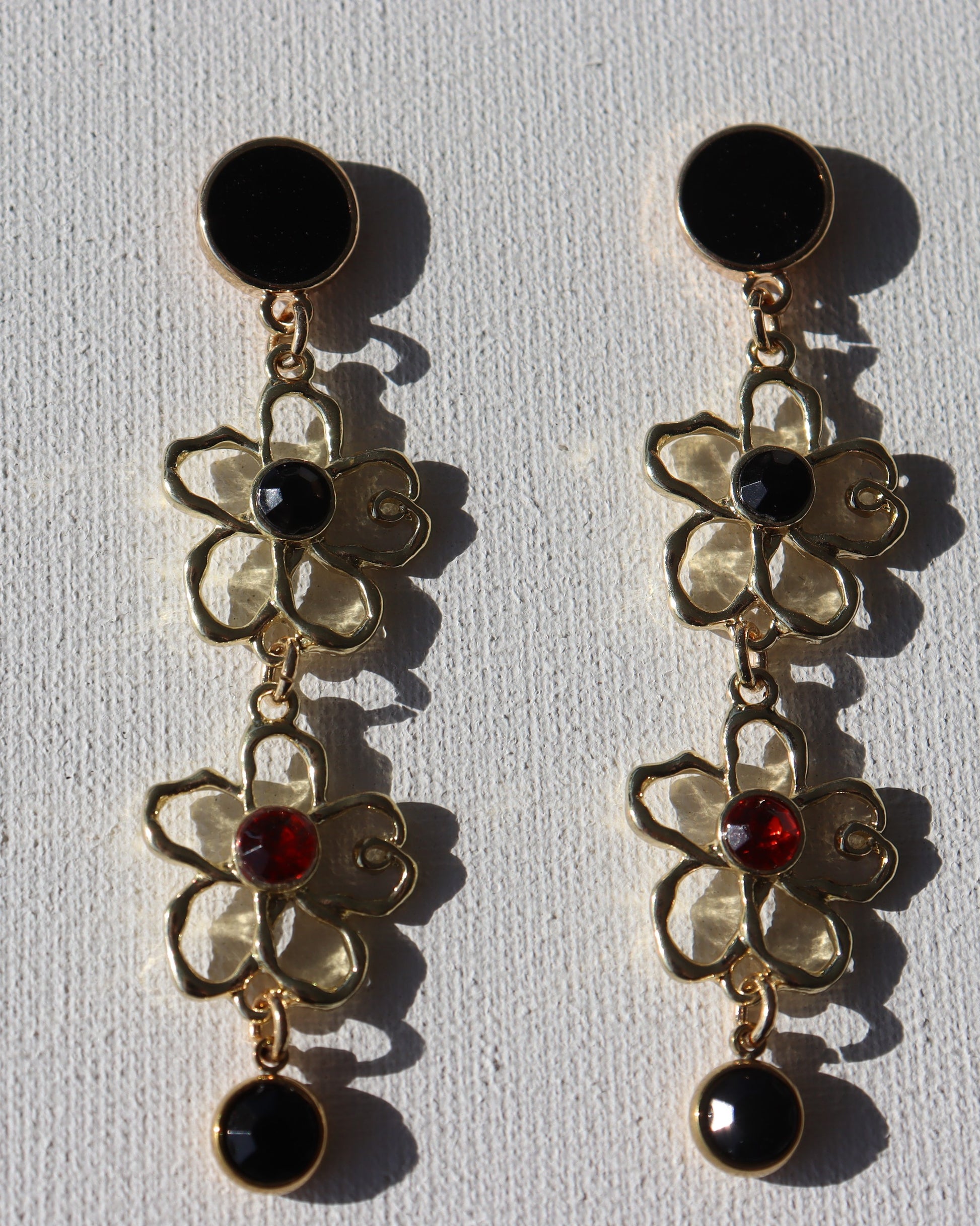Goudkleurige zwarte ronde stekertjes met goudkleurige bloemen met zwarte en rode steen en zwarte zirkonia hanger