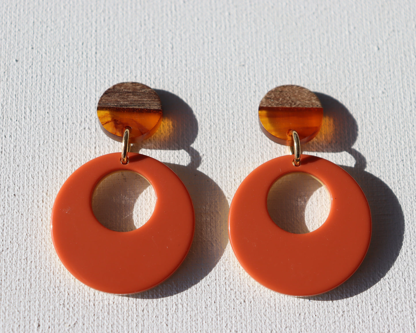 Houten met oranje ronde oorstekers met oranje met okergele cirkel met gat