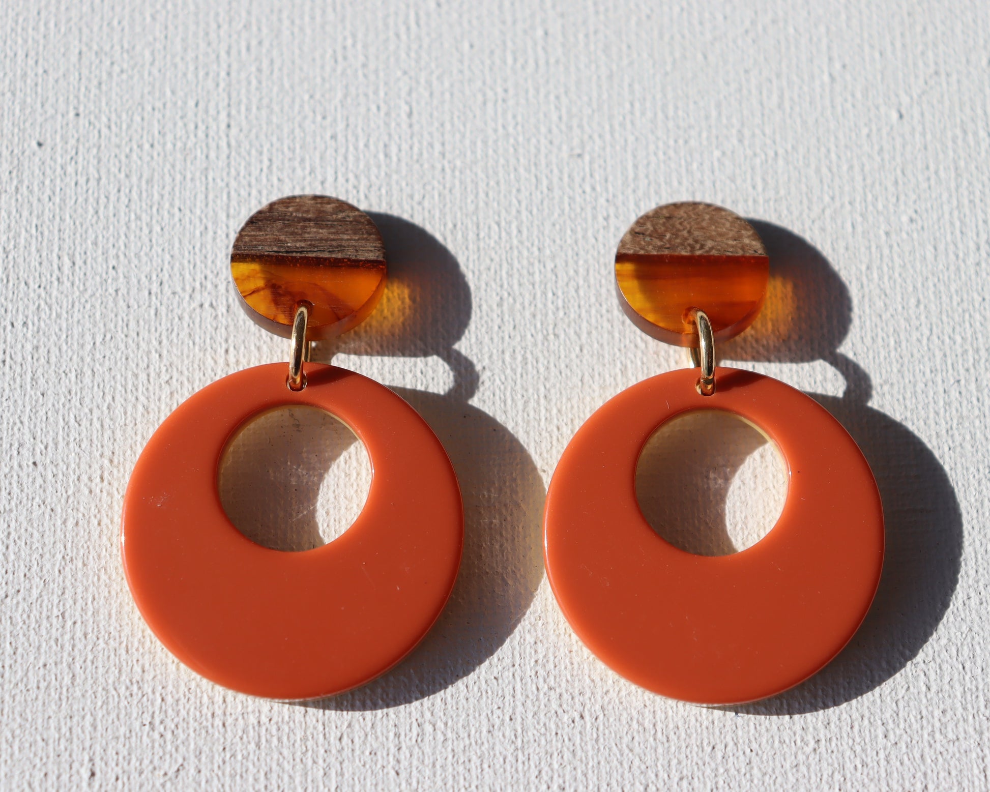 Houten met oranje ronde oorstekers met oranje met okergele cirkel met gat