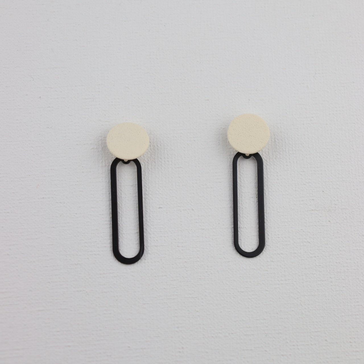 Ivoor ronde oorstekers met  zwarte ovale hanger
