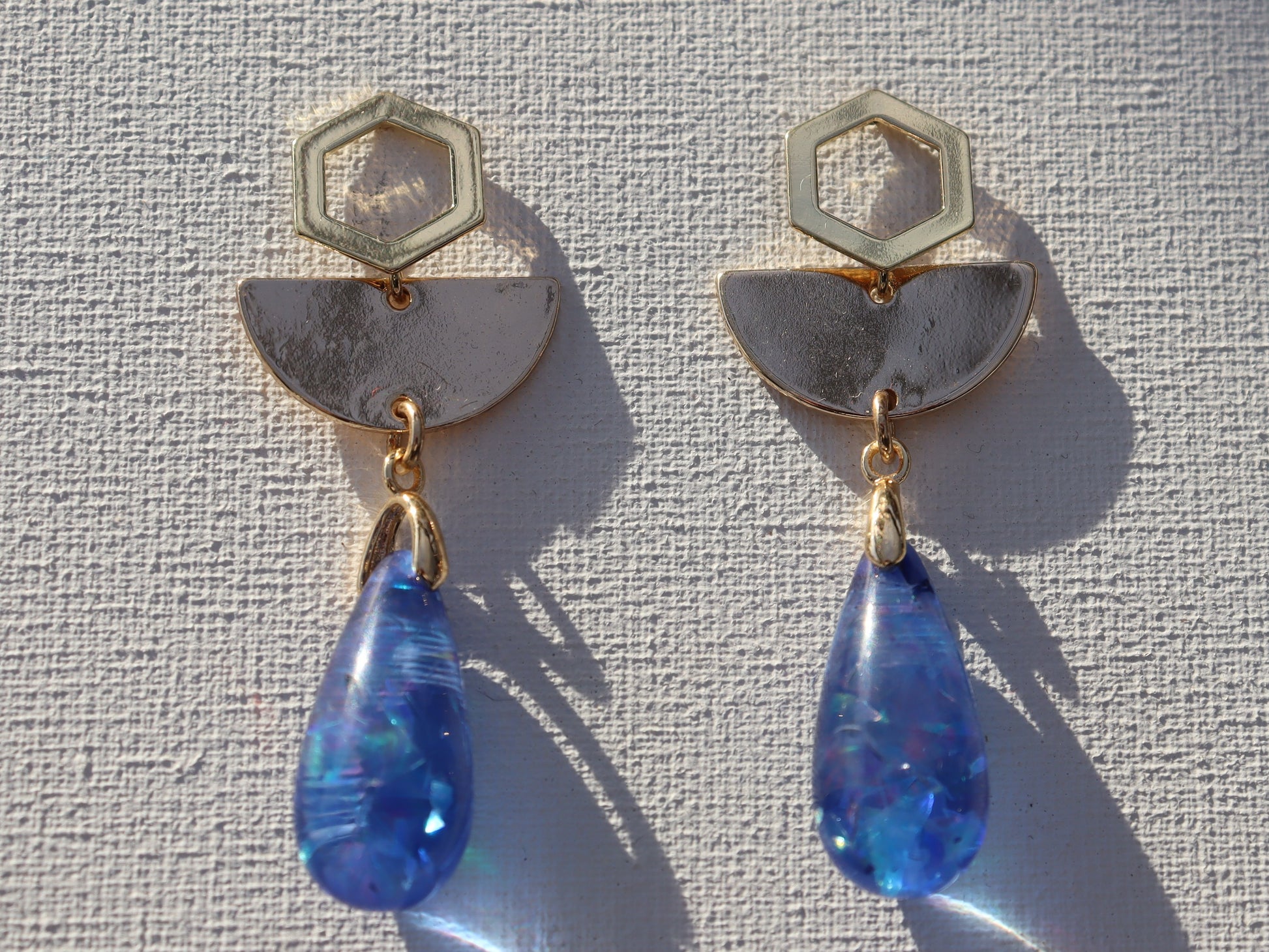 Luxe goudkleurige zeshoekige oorbellen met halve maantjes hangers en blauwe druppels