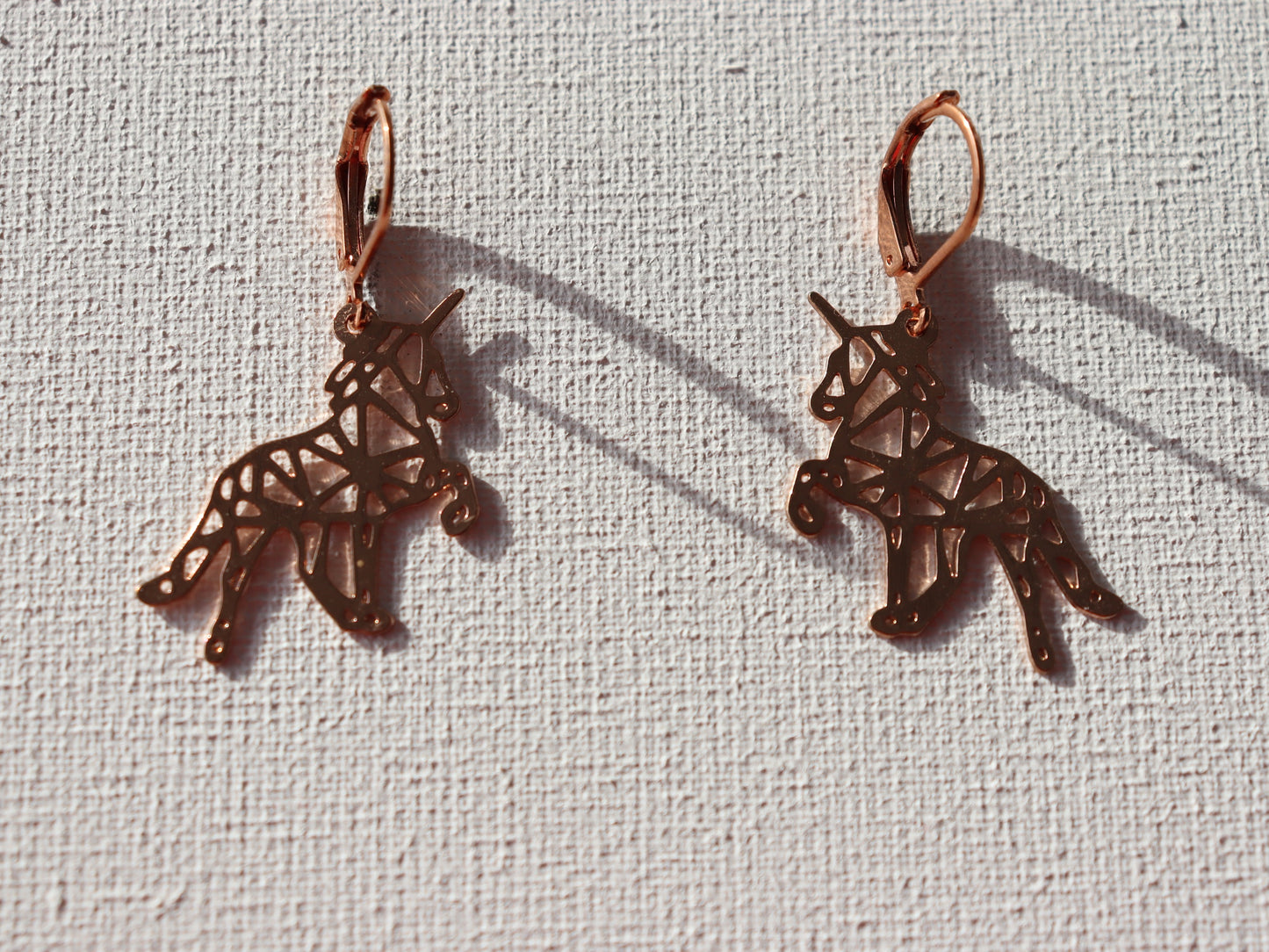 Rosekleurige oorbelringen met rosekleurige origami eenhoorns