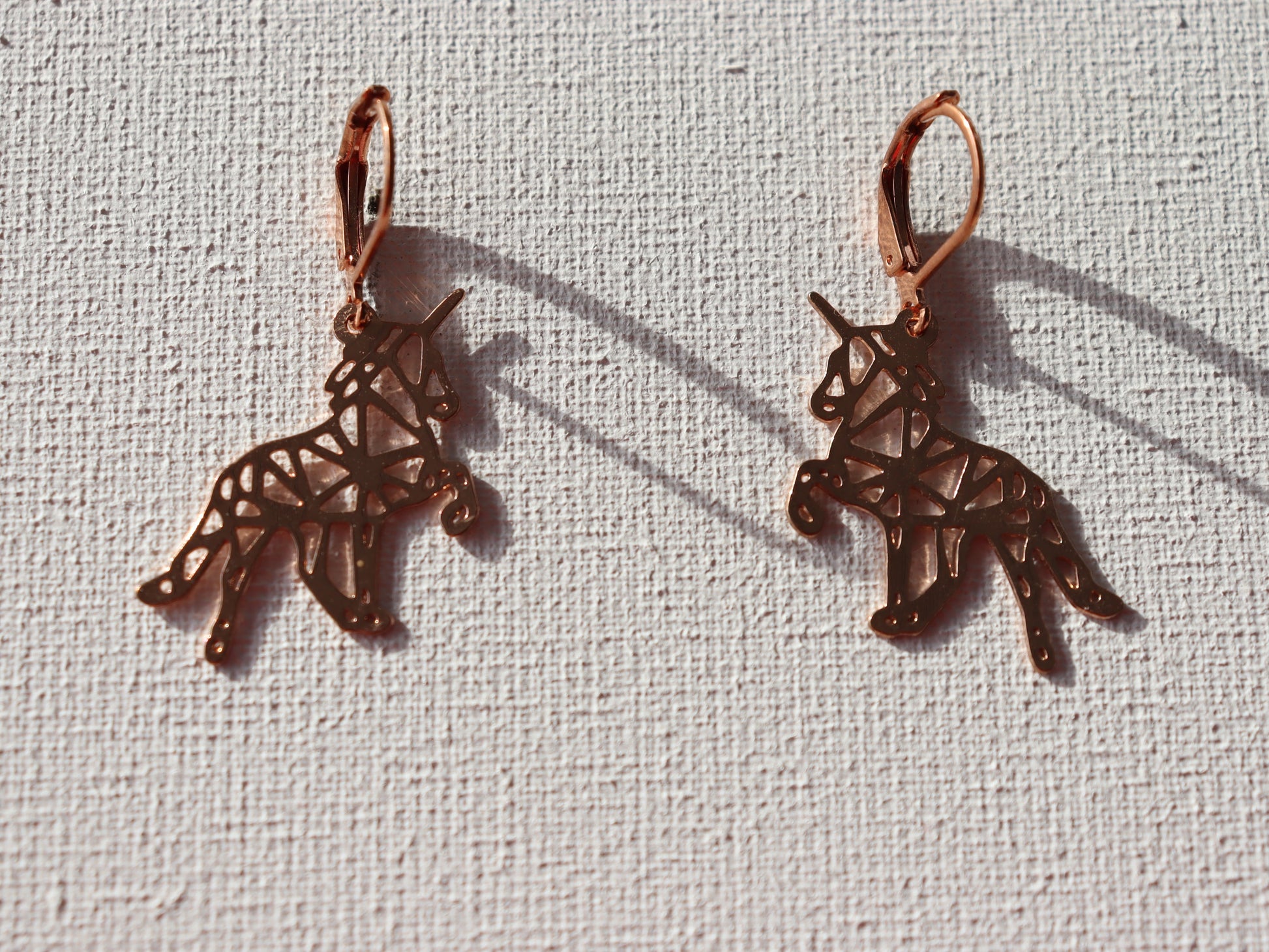Rosekleurige oorbelringen met rosekleurige origami eenhoorns