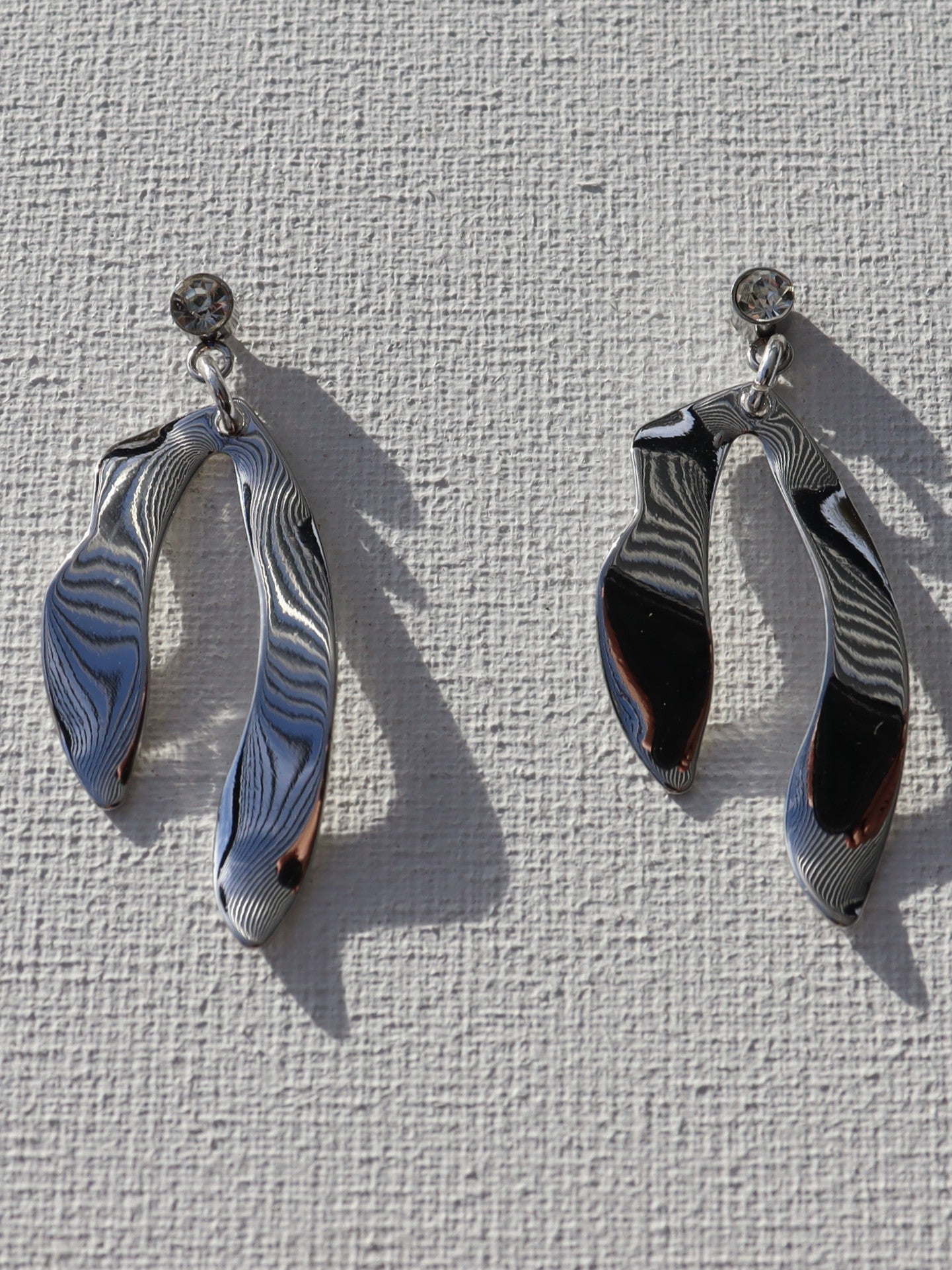 Zilverkleurige steenstekertjes met zilverkleurige kronkelhanger