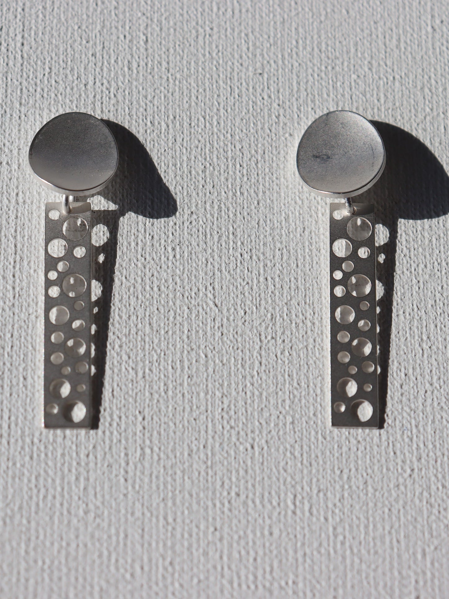 Zilverkleurige matte ovale stekertjes met zilverkleurige staafjes met ronde gaten