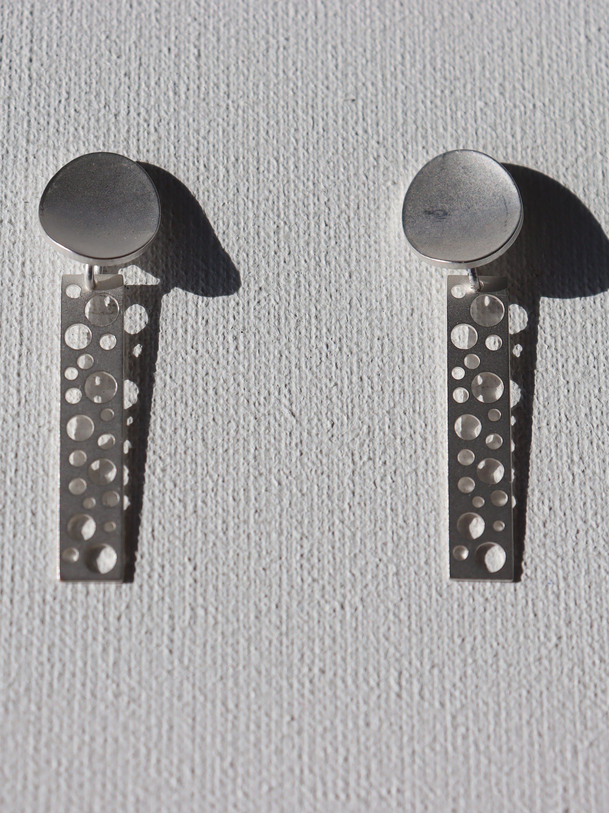 Zilverkleurige matte ovale stekertjes met zilverkleurige staafjes met ronde gaten