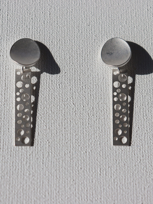 Zilverkleurige matte ovale stekertjes met zilverkleurige staafjes met ronde gaten