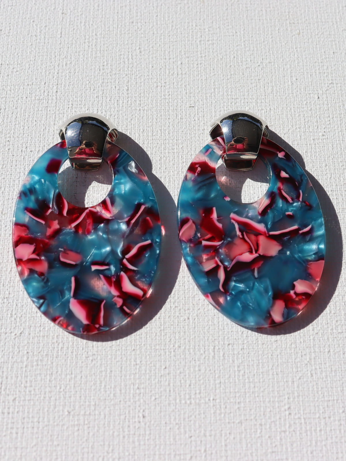 Zilverkleurige oorstekertjes met blauwe en roze ovale hanger