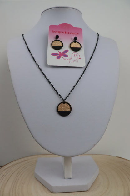 Zwarte_ketting_met_goudkleurige_ronde_en_zwarte_halve_cirkel_en_zwarte_oorknopjes_met_goudkleurige_ronde_en_zwarte_halve_cirkel