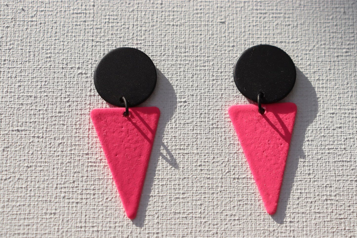 Zwarte oorstekers met fluo roze driehoeken