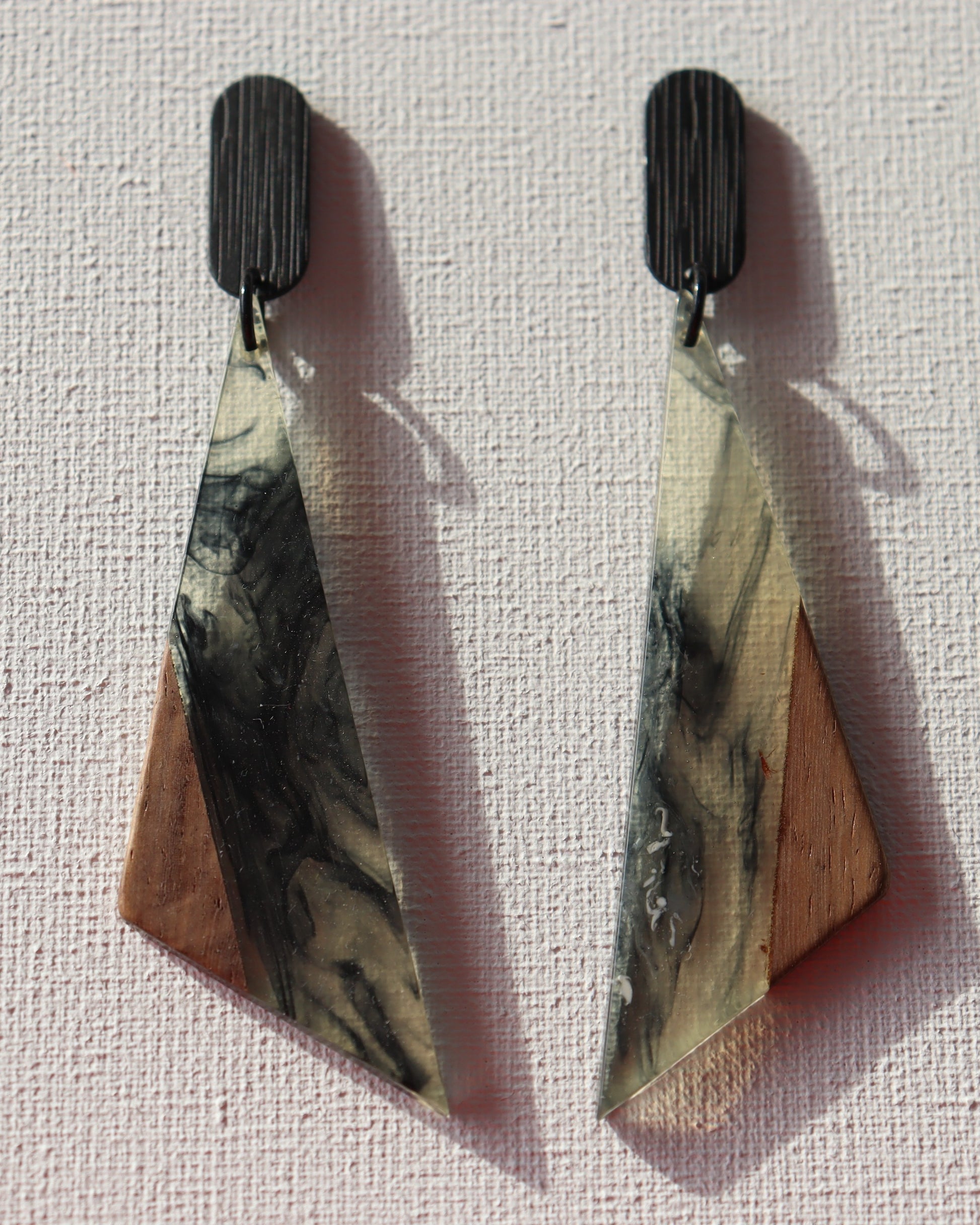 Zwarte ovale oorstekers met driehoek met hout en epoxy