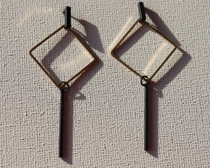 Zwarte staafjes met goudkleurige ruit hanger en zwarte staafjes