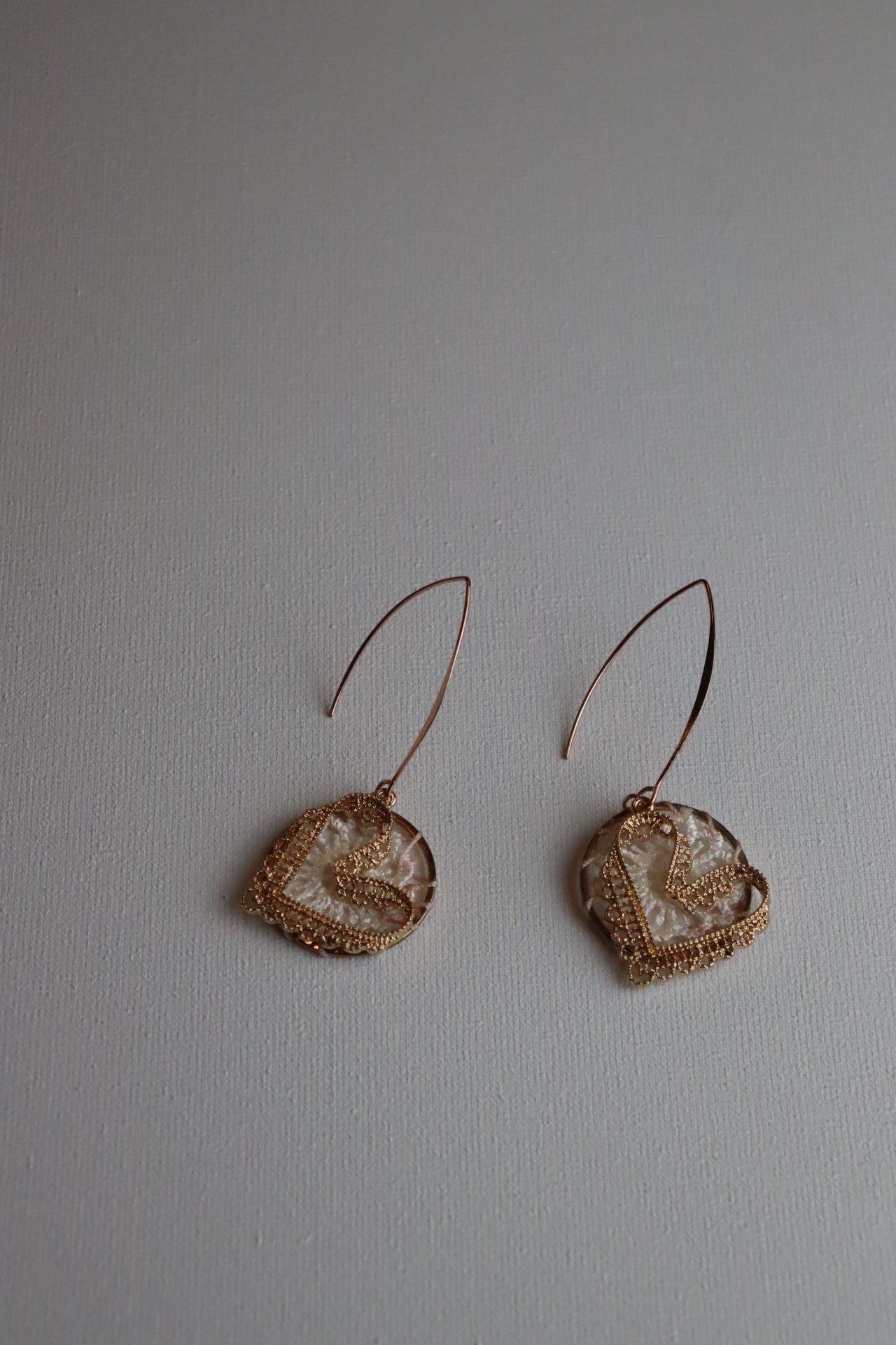 Goudkleurige oorhaken met roze gehaakte cirkels en goudkleurige gehaakte hartjes